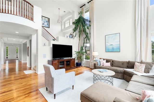 6032 Umber St, Arvada, CO 80403 - living room featuring light wood-type flooring, a towering ceiling, and baseboards
