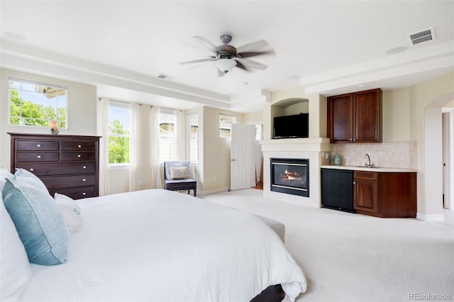 6032 Umber St, Arvada, CO 80403 - bedroom with fridge, baseboards, a glass covered fireplace, a sink, and light colored carpet