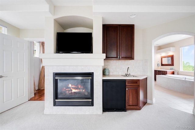 6032 Umber St, Arvada, CO 80403 - bar area featuring refrigerator, light colored carpet, a fireplace, and a sink