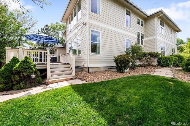 6032 Umber St, Arvada, CO 80403 - view of side of home featuring a lawn and a wooden deck