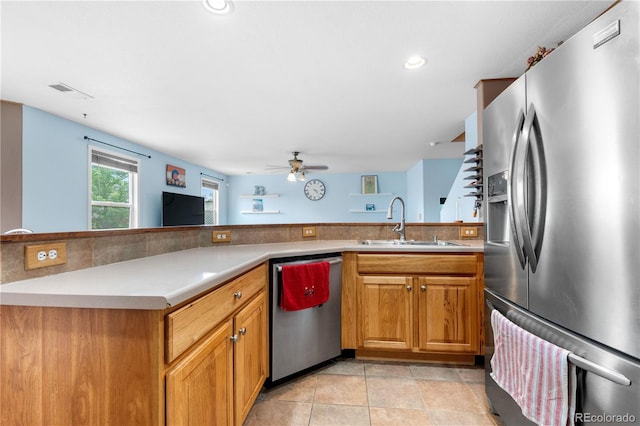 13664 Linden Ct, Thornton, CO 80602 - kitchen with stainless steel appliances, a sink, ceiling fan, light countertops, and brown cabinetry