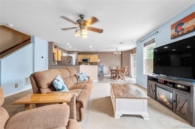 13664 Linden Ct, Thornton, CO 80602 - living area featuring light carpet, a ceiling fan, a chandelier, baseboards, and a glass covered fireplace