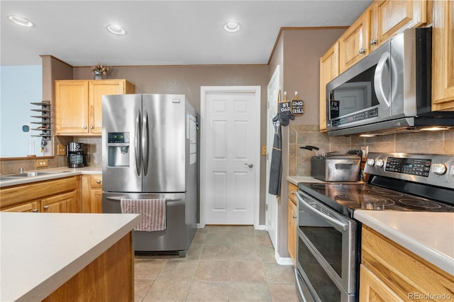 13664 Linden Ct, Thornton, CO 80602 - kitchen with stainless steel appliances, decorative backsplash, light countertops, light brown cabinetry, and recessed lighting