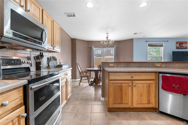 13664 Linden Ct, Thornton, CO 80602 - kitchen featuring appliances with stainless steel finishes, a chandelier, light tile patterned flooring, light countertops, and recessed lighting