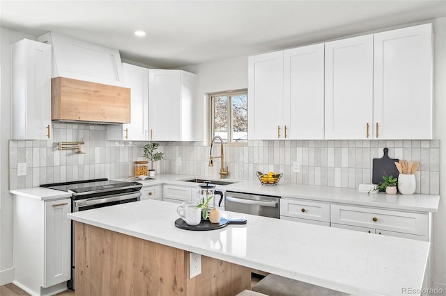 kitchen with a breakfast bar, sink, decorative backsplash, appliances with stainless steel finishes, and white cabinetry