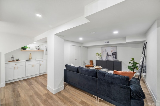 living room featuring sink and light hardwood / wood-style flooring