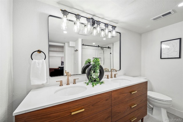 bathroom featuring vanity, a textured ceiling, toilet, and a shower with shower door