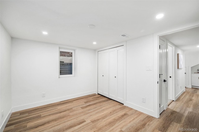 unfurnished bedroom with light hardwood / wood-style flooring and a closet