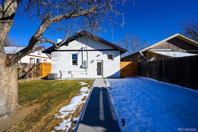 rear view of property featuring central AC and a yard