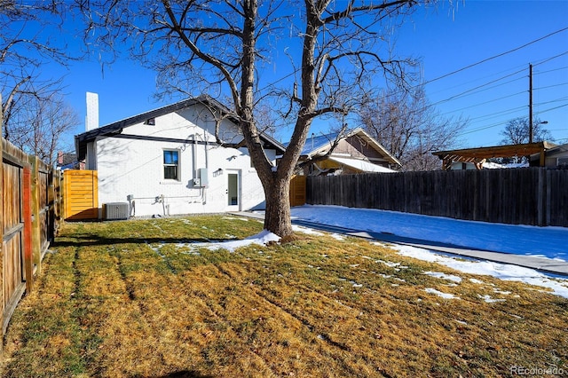 rear view of property with a yard and central AC