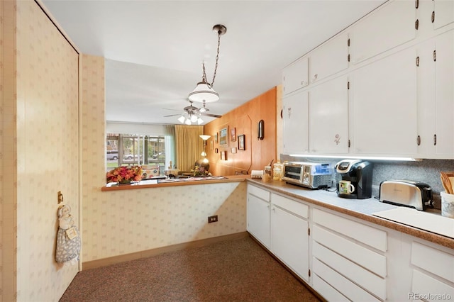 kitchen with ceiling fan, white cabinets, carpet flooring, and pendant lighting