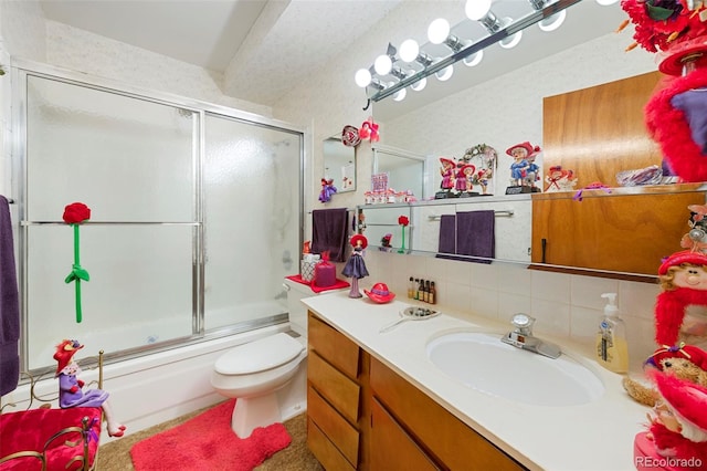 full bathroom with vanity, toilet, bath / shower combo with glass door, and tasteful backsplash