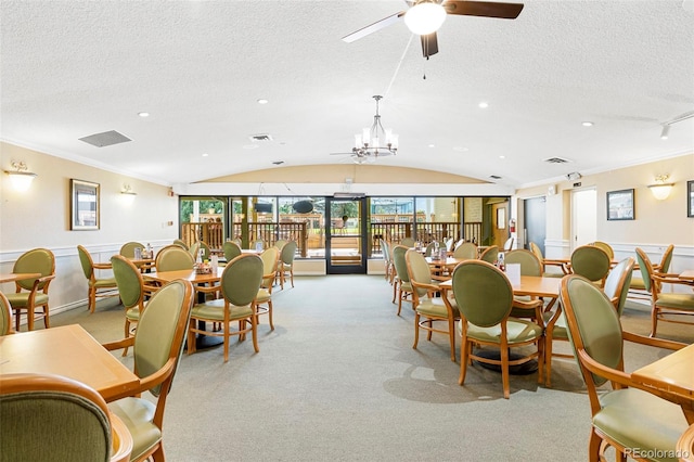 carpeted dining room featuring ceiling fan with notable chandelier, a textured ceiling, and lofted ceiling