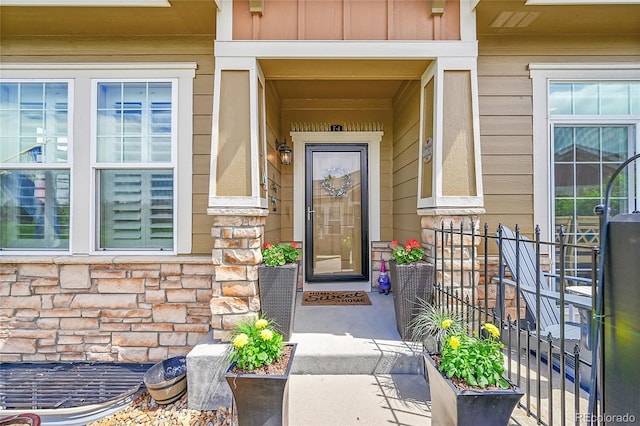 property entrance featuring covered porch and stone siding