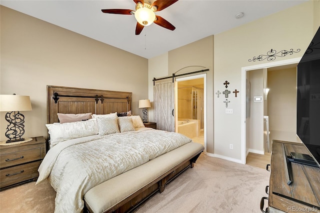 bedroom featuring a ceiling fan, light colored carpet, a barn door, baseboards, and ensuite bathroom