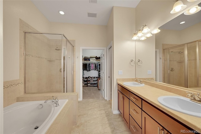 full bath featuring a sink, double vanity, a shower stall, and a garden tub
