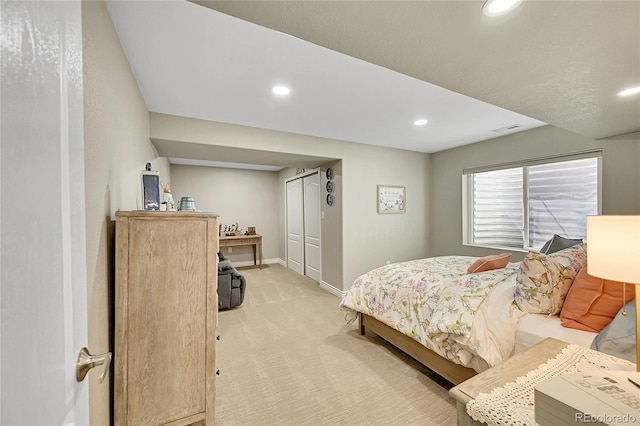 bedroom with visible vents, light colored carpet, baseboards, a closet, and recessed lighting