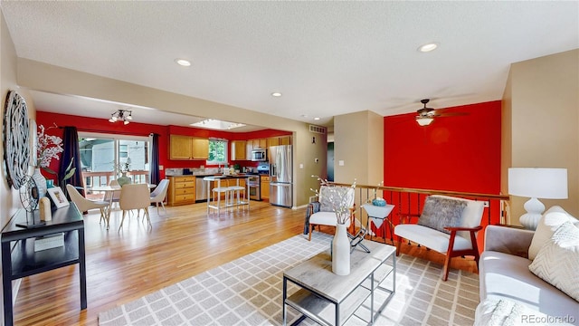 6631 Welch Ct, Arvada, CO 80004 - living room with light wood finished floors, ceiling fan, and recessed lighting