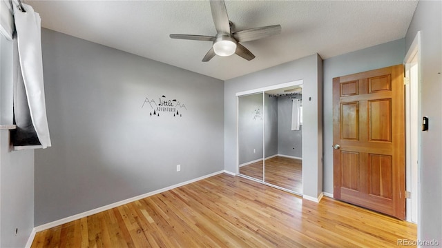 6631 Welch Ct, Arvada, CO 80004 - unfurnished bedroom with light wood-style flooring, a closet, baseboards, ceiling fan, and a textured ceiling