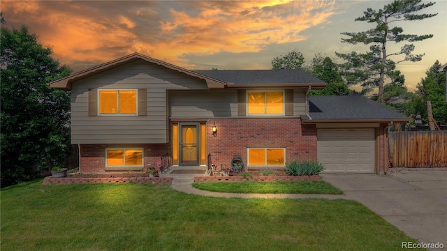 6631 Welch Ct, Arvada, CO 80004 - raised ranch featuring an attached garage, brick siding, and driveway