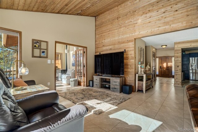 tiled living room featuring wood walls, wooden ceiling, and high vaulted ceiling