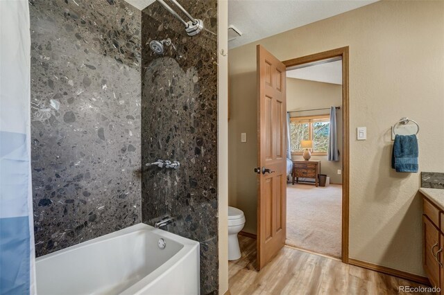 full bathroom featuring vanity, vaulted ceiling, shower / bath combo with shower curtain, hardwood / wood-style floors, and toilet