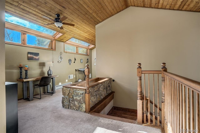 interior space with light carpet, baseboard heating, wooden ceiling, and vaulted ceiling with skylight