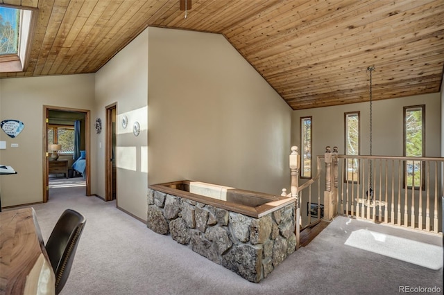 interior space featuring a skylight, light carpet, high vaulted ceiling, and wood ceiling