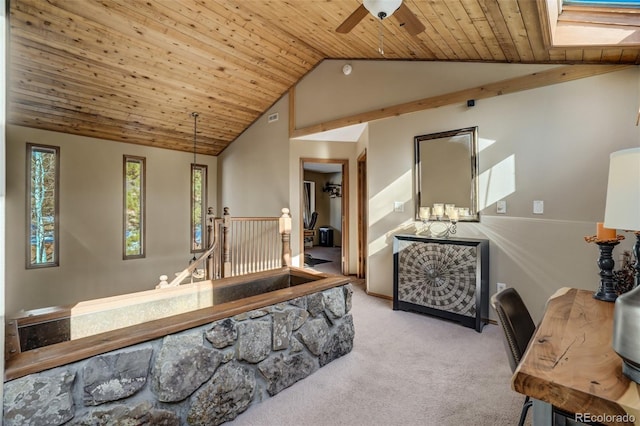 interior space featuring vaulted ceiling with skylight, light colored carpet, and wooden ceiling