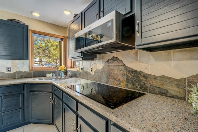 320 Morning Sun Dr, Woodland Park, CO 80863 - kitchen with stainless steel microwave, black electric cooktop, a sink, tasteful backsplash, and light stone countertops