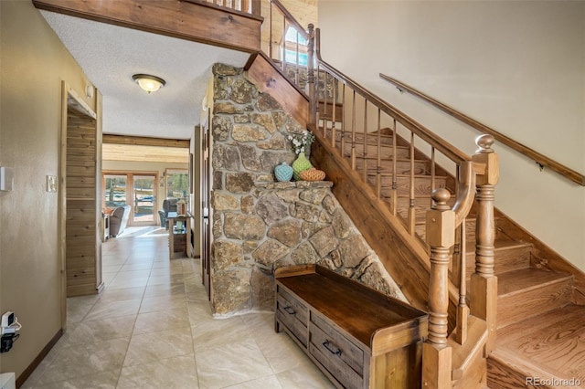 320 Morning Sun Dr, Woodland Park, CO 80863 - stairs featuring healthy amount of natural light, a textured ceiling, and baseboards