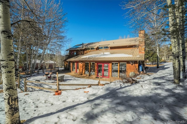 320 Morning Sun Dr, Woodland Park, CO 80863 - snow covered rear of property with a chimney, a standing seam roof, and metal roof