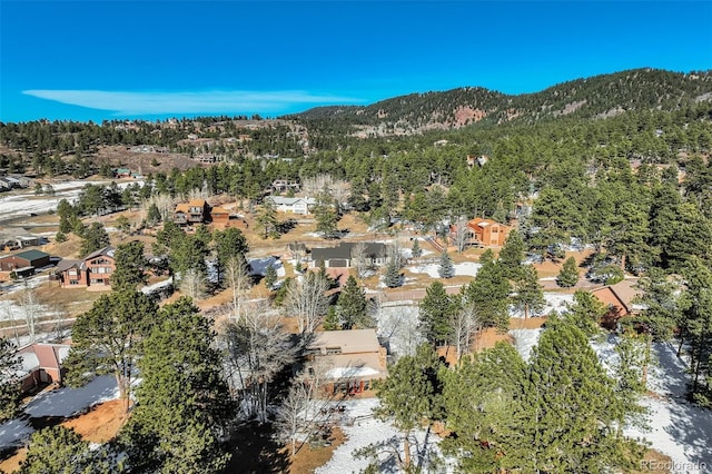 320 Morning Sun Dr, Woodland Park, CO 80863 - aerial view of property and surrounding area featuring a forest, a mountain backdrop, and nearby suburban area