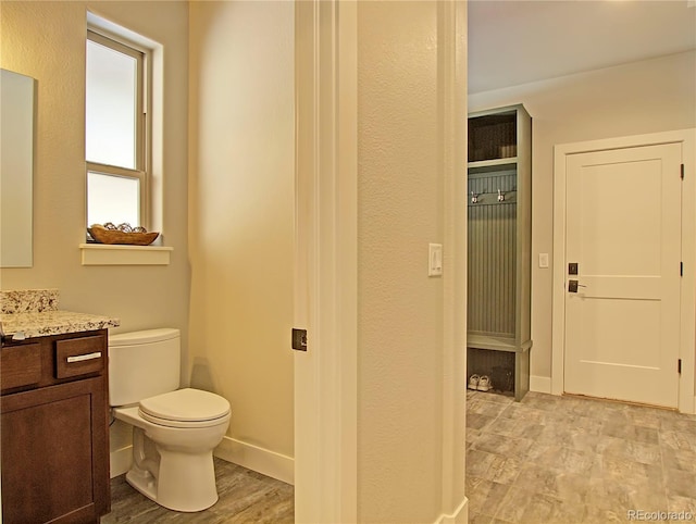 bathroom featuring vanity, hardwood / wood-style flooring, and toilet