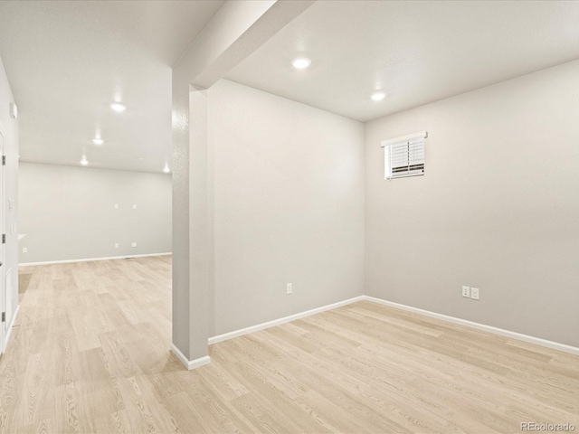 empty room featuring baseboards, light wood-type flooring, and recessed lighting