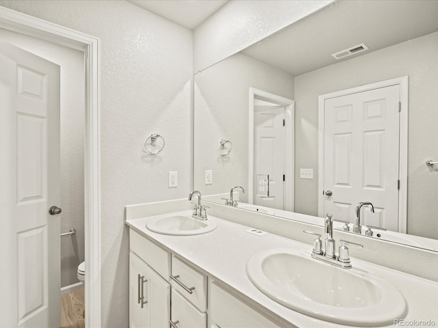 full bathroom featuring a sink, visible vents, and toilet