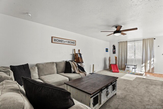 living room featuring a textured ceiling, carpet floors, and ceiling fan