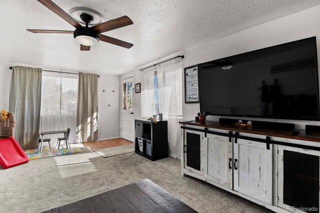 interior space featuring light hardwood / wood-style flooring, a textured ceiling, and ceiling fan