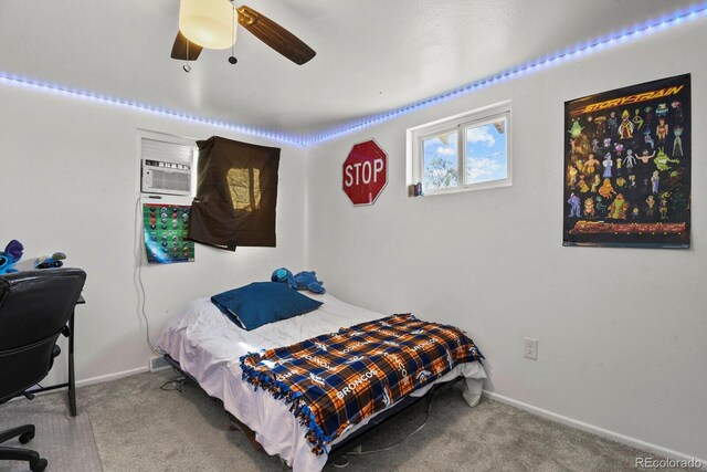 carpeted bedroom with an AC wall unit and ceiling fan