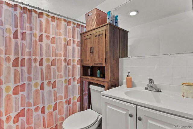 bathroom featuring tasteful backsplash, toilet, tile walls, a shower with curtain, and vanity