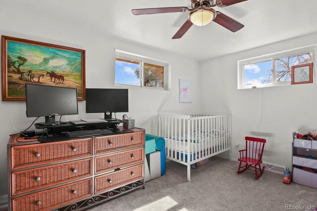 carpeted bedroom with a nursery area and ceiling fan