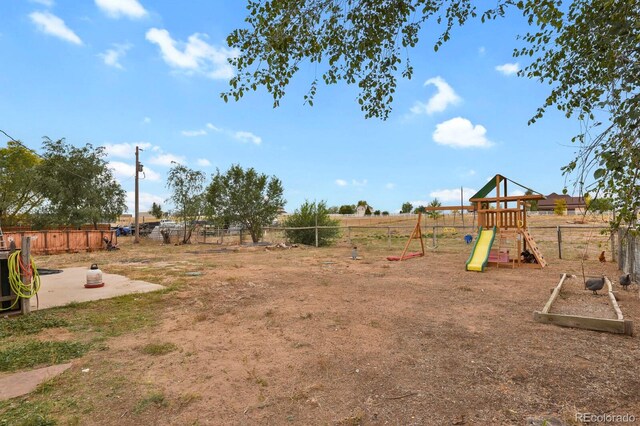 view of playground featuring a patio area and a rural view