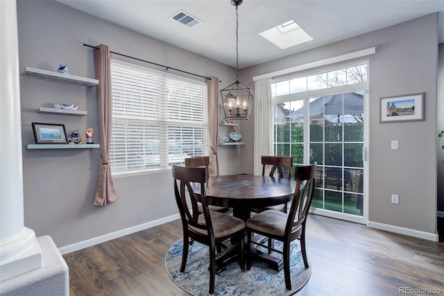 3993 S Dillon Way Unit 104, Aurora, CO 80014 - dining space with a chandelier, wood finished floors, a skylight, and baseboards