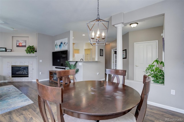 3993 S Dillon Way Unit 104, Aurora, CO 80014 - dining space featuring a tiled fireplace, dark wood-style floors, baseboards, recessed lighting, and a chandelier