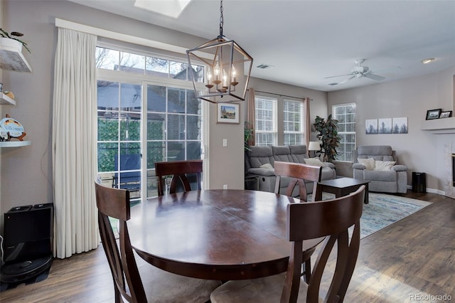 3993 S Dillon Way Unit 104, Aurora, CO 80014 - dining room featuring wood finished floors, a chandelier, a ceiling fan, and baseboards