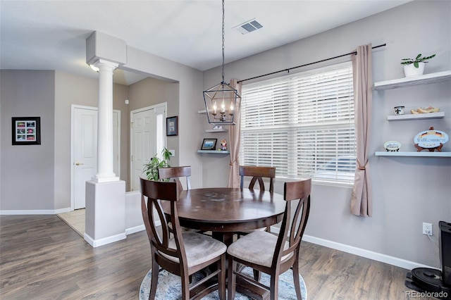 3993 S Dillon Way Unit 104, Aurora, CO 80014 - dining room featuring decorative columns, wood finished floors, baseboards, and a chandelier