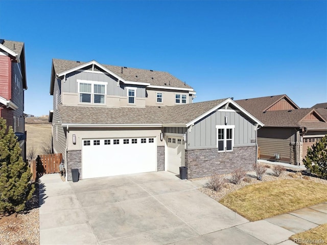 craftsman inspired home with an attached garage, driveway, stone siding, roof with shingles, and board and batten siding