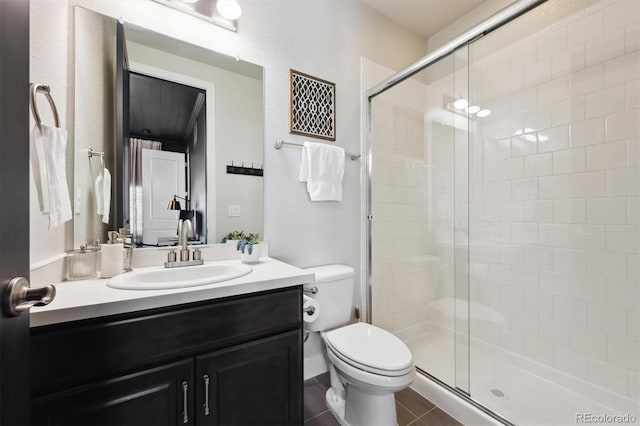 bathroom with a shower stall, toilet, and vanity