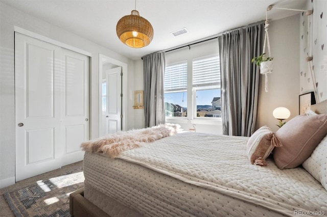 carpeted bedroom with a closet and visible vents