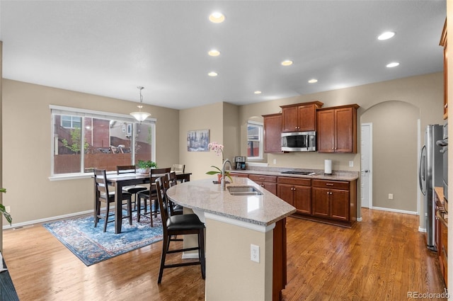 16685 E 101st Ave, Commerce City, CO 80022 - kitchen with a sink, arched walkways, stainless steel appliances, and a center island with sink